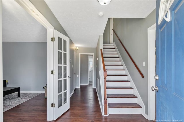 foyer with baseboards, stairway, dark wood finished floors, and a textured ceiling