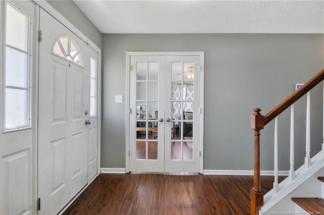 entryway featuring dark wood-style flooring, stairway, baseboards, and a textured ceiling