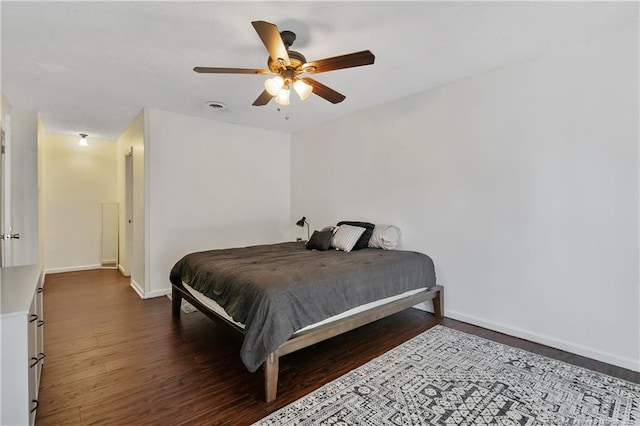 bedroom with ceiling fan, wood finished floors, visible vents, and baseboards