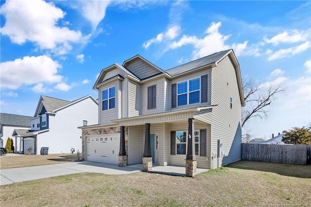 view of front of home with covered porch, fence, a garage, driveway, and a front lawn