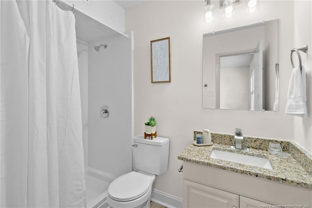 bathroom featuring a stall shower, vanity, and toilet