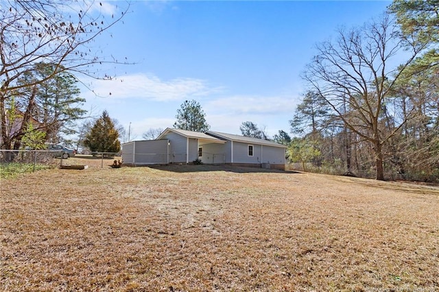 back of house with a lawn and fence