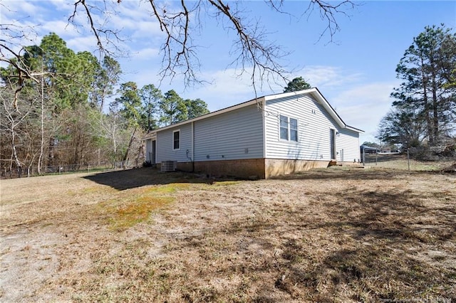 view of home's exterior featuring a lawn, fence, and central AC