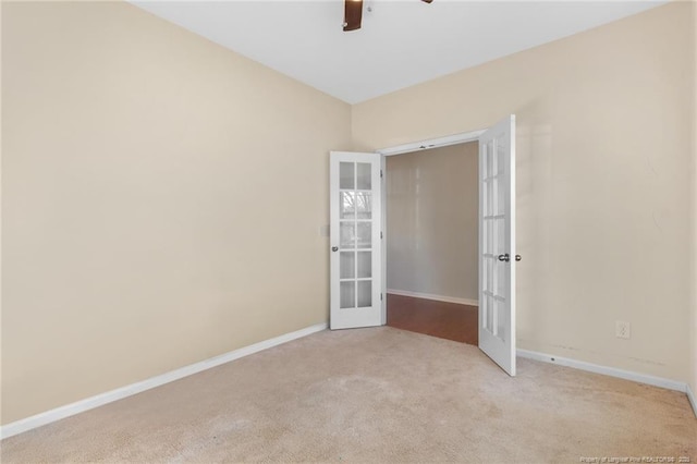 unfurnished room featuring light carpet, french doors, a ceiling fan, and baseboards