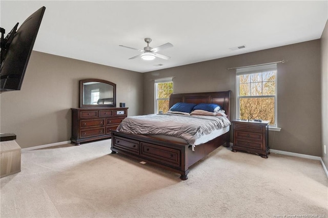 bedroom with baseboards, visible vents, a ceiling fan, and light colored carpet