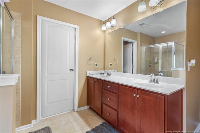 full bathroom with double vanity, a sink, a shower stall, and tile patterned floors