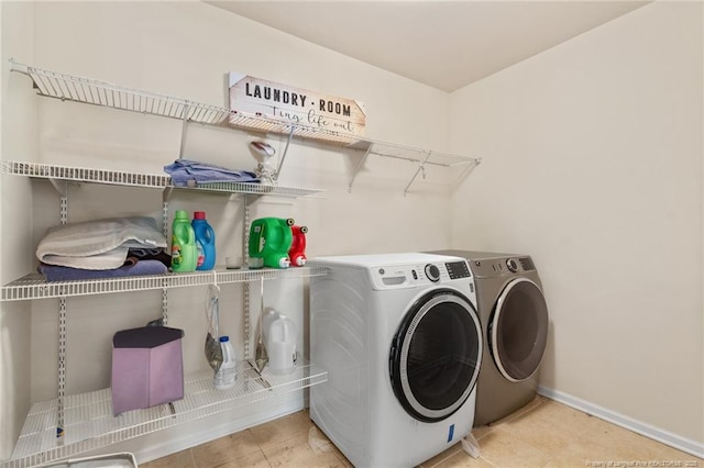 clothes washing area with laundry area, washer and clothes dryer, and baseboards