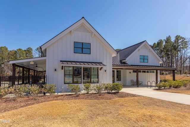 modern farmhouse style home featuring a standing seam roof, ceiling fan, metal roof, and board and batten siding