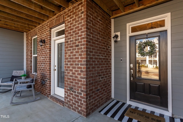 doorway to property featuring brick siding