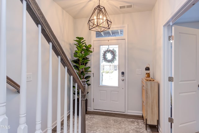 foyer entrance with visible vents, stairway, light wood-style flooring, and baseboards