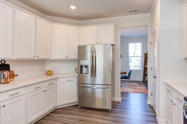 kitchen with visible vents, white cabinets, wood finished floors, light countertops, and stainless steel refrigerator with ice dispenser