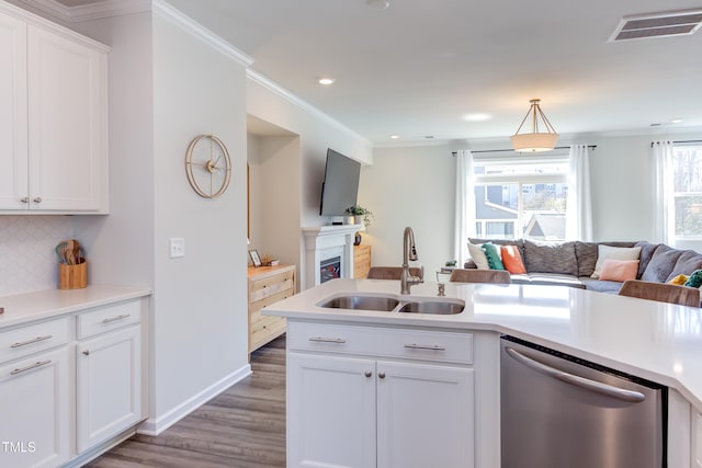 kitchen with a sink, white cabinetry, open floor plan, light countertops, and stainless steel dishwasher