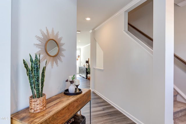 corridor featuring recessed lighting, wood finished floors, baseboards, ornamental molding, and stairway