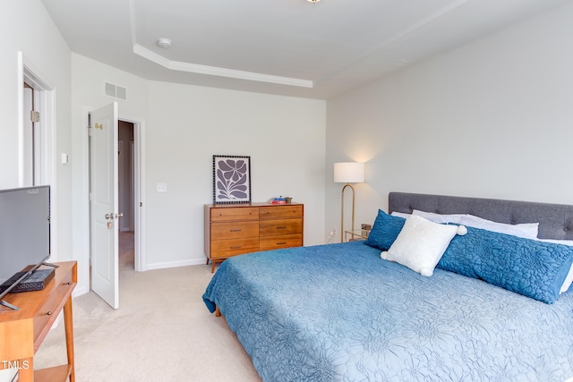 bedroom with a tray ceiling, carpet flooring, visible vents, and baseboards