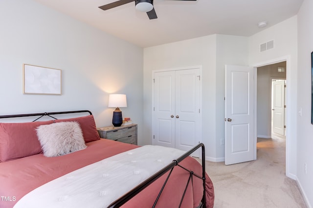 bedroom with baseboards, visible vents, a closet, and light colored carpet