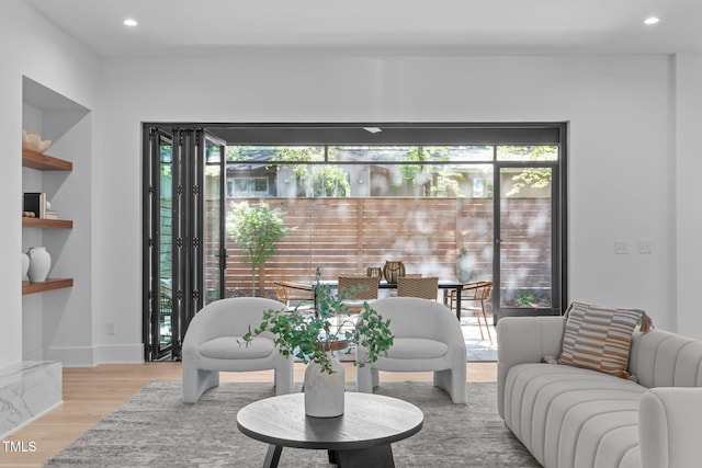 living area featuring light wood-type flooring, a wealth of natural light, baseboards, and recessed lighting