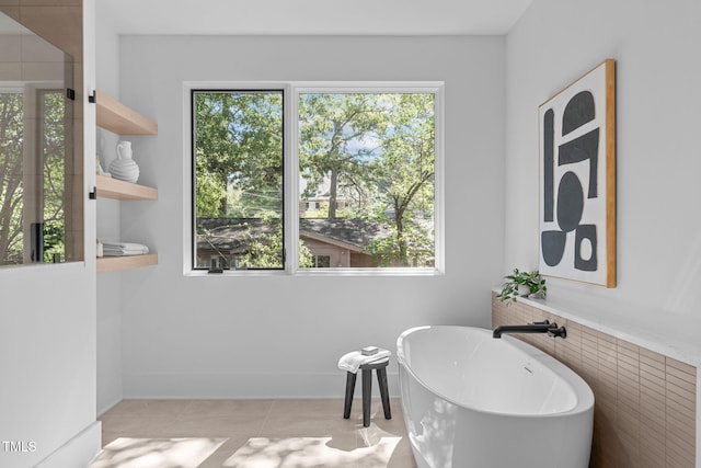 bathroom with a freestanding tub and tile patterned floors