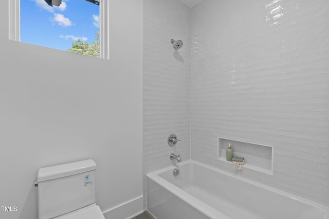 bathroom with baseboards, shower / bathing tub combination, and toilet