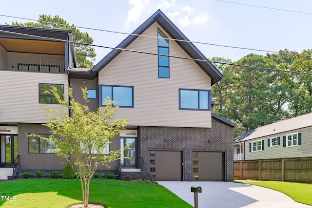 view of front facade with a front yard, concrete driveway, brick siding, and fence