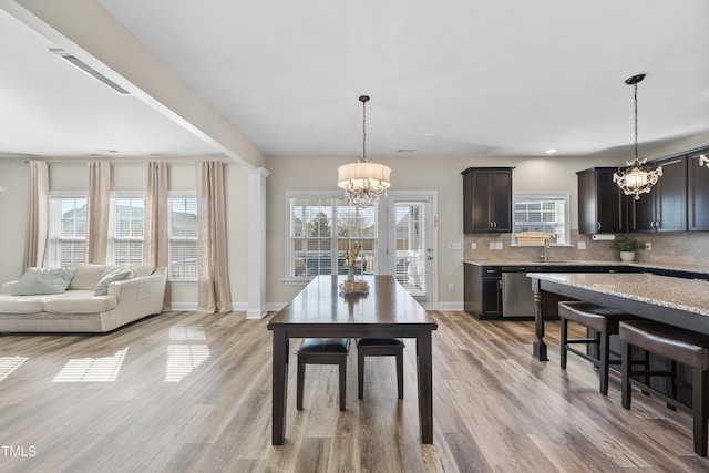 dining area with baseboards, recessed lighting, light wood-style flooring, and a notable chandelier