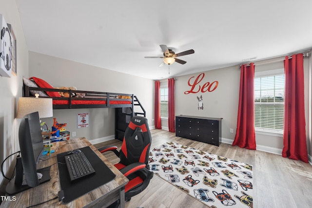 bedroom featuring light wood-style floors, baseboards, visible vents, and ceiling fan