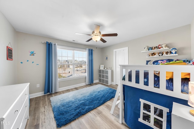 bedroom featuring visible vents, wood finished floors, a ceiling fan, and baseboards