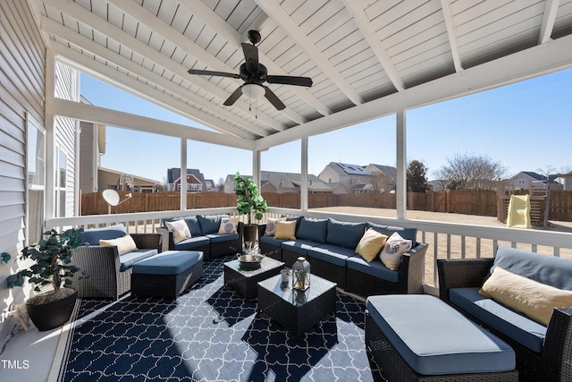 sunroom with lofted ceiling with beams, ceiling fan, plenty of natural light, and wooden ceiling