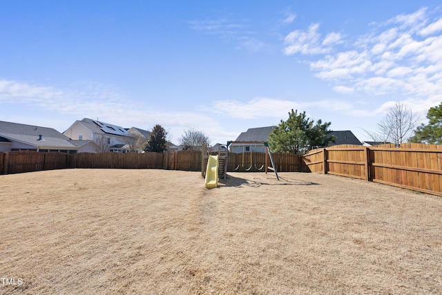 view of yard with a playground and a fenced backyard