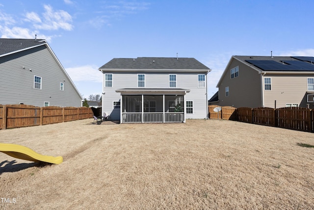 back of property with a sunroom and a fenced backyard