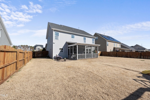 rear view of property with a sunroom, a fenced backyard, and a residential view