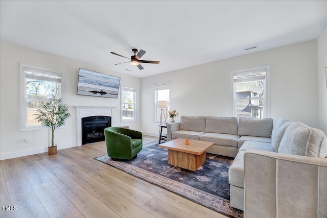 living room with a healthy amount of sunlight, light wood-style flooring, and visible vents