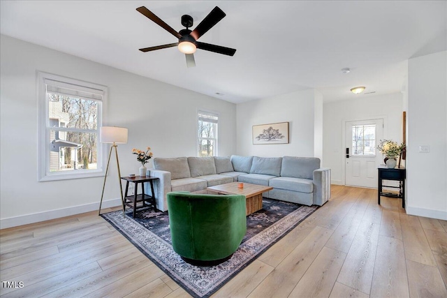 living area with ceiling fan, light wood-style flooring, and baseboards