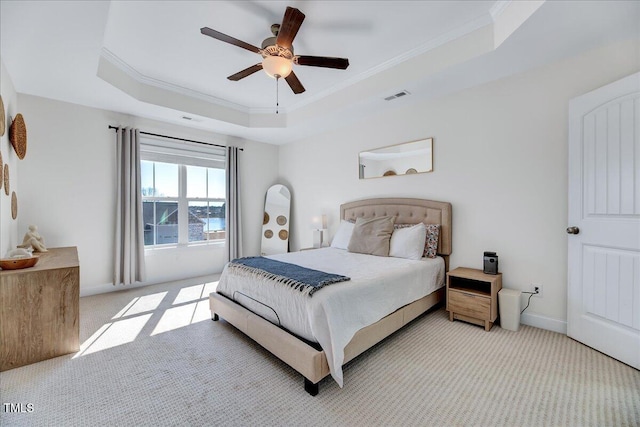 bedroom featuring a tray ceiling, crown molding, visible vents, light carpet, and baseboards