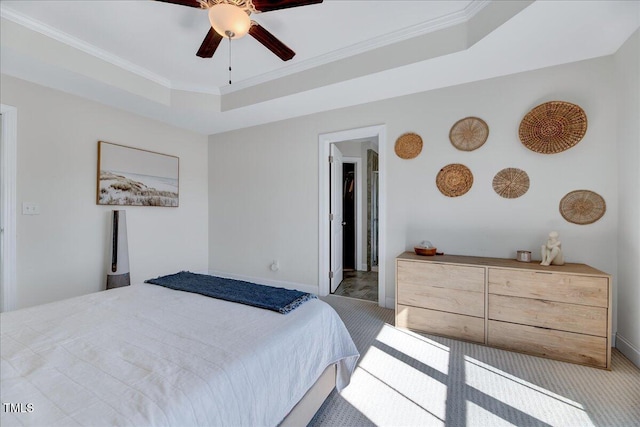 carpeted bedroom featuring a tray ceiling, crown molding, and ceiling fan