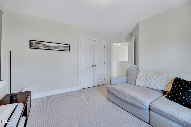 living area featuring baseboards and light colored carpet