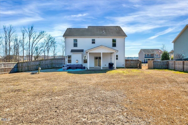 rear view of house with a fenced backyard, a yard, and outdoor lounge area