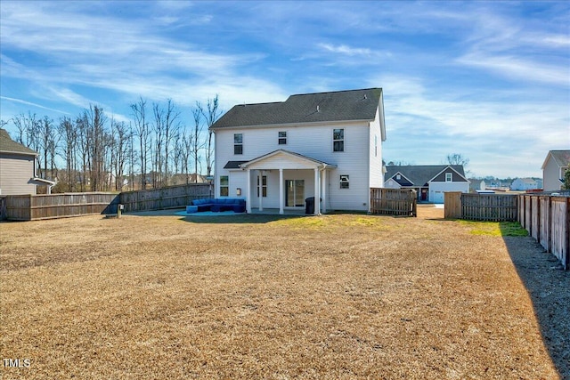 back of property with a fenced backyard and a lawn