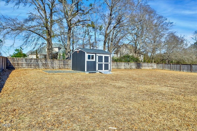 view of yard with a storage unit, an outdoor structure, and a fenced backyard