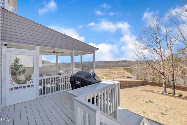 deck featuring area for grilling, fence, and a sunroom