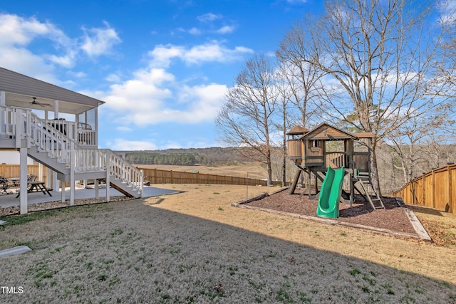 view of yard with a patio area, a fenced backyard, stairs, and a playground