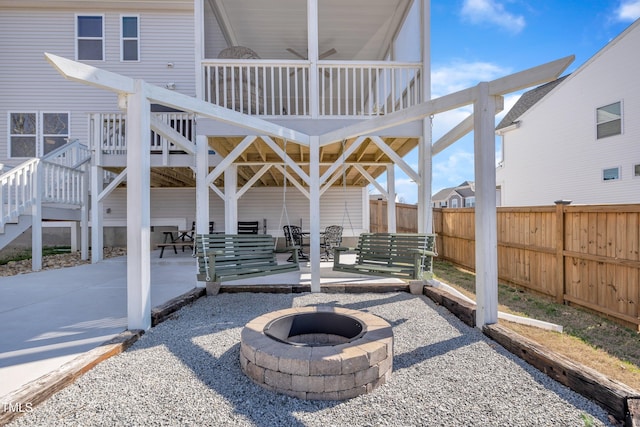 view of patio featuring a fire pit, stairway, and fence