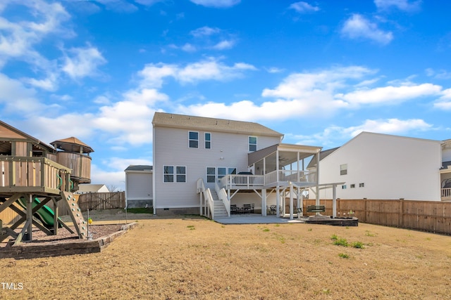 rear view of property featuring a playground, a sunroom, crawl space, a patio area, and a fenced backyard