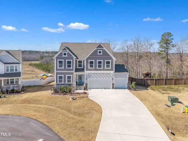 traditional home with concrete driveway, board and batten siding, fence, a garage, and stone siding