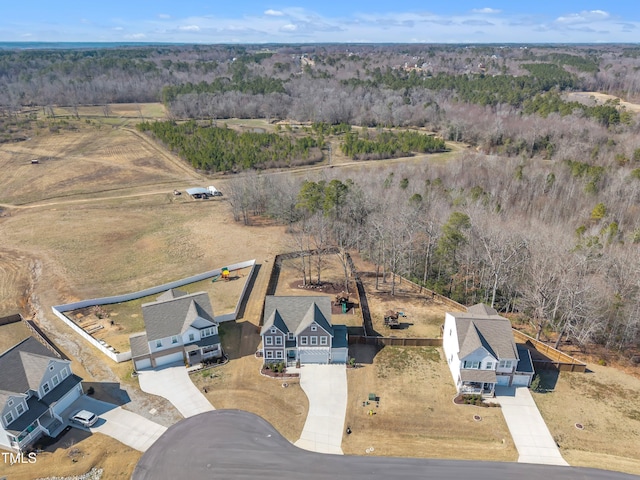 birds eye view of property featuring a view of trees