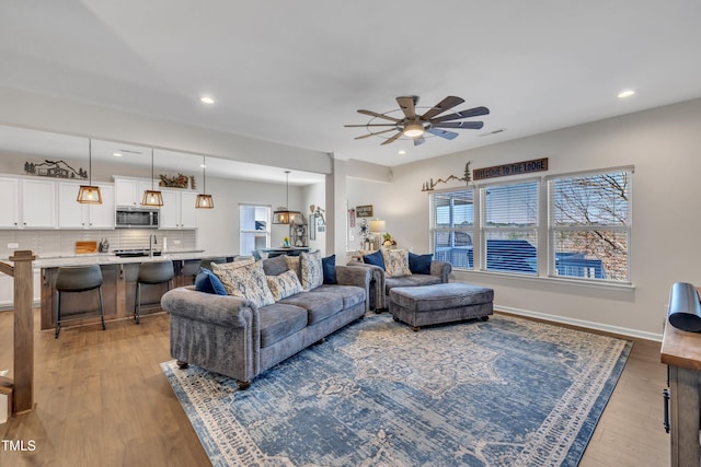 living area featuring recessed lighting, wood finished floors, visible vents, baseboards, and a ceiling fan