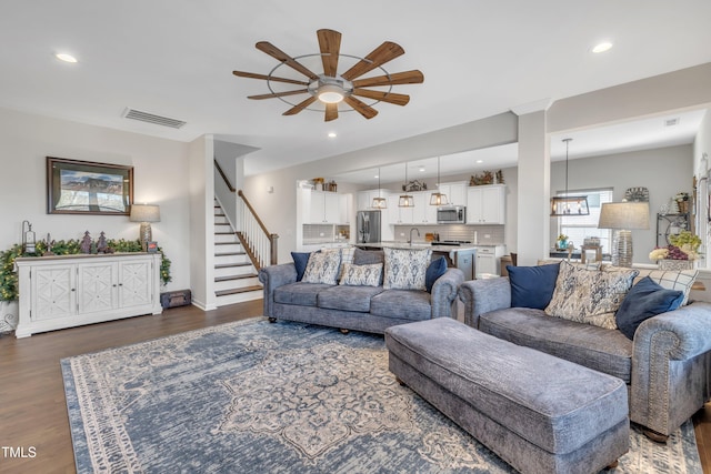 living room with stairs, dark wood finished floors, visible vents, and recessed lighting