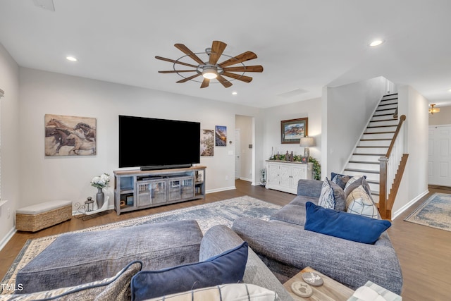 living area featuring baseboards, stairway, wood finished floors, and recessed lighting