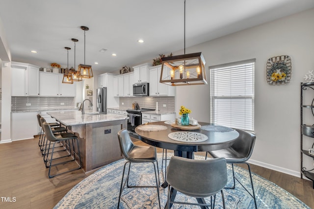 dining space featuring dark wood-style floors, recessed lighting, a chandelier, and baseboards