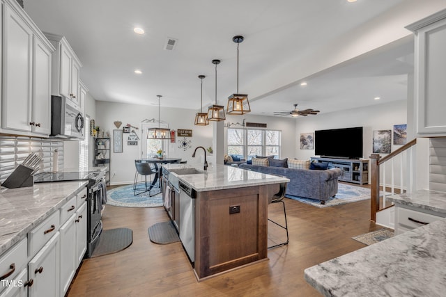 kitchen with visible vents, dark wood-style floors, appliances with stainless steel finishes, open floor plan, and a sink