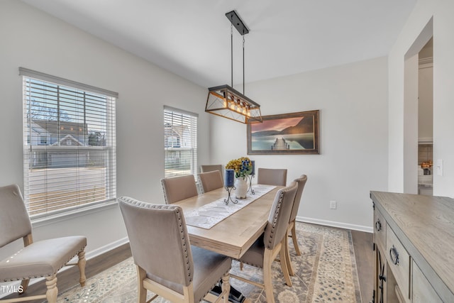 dining space with baseboards and wood finished floors